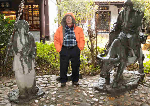 Maestro Ming, caposcuola dei corsi di riflessologia  plantare On Zon Su  per riflessologo, in giardino tra statue di immortali taoisti.