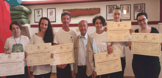 Gruppo di neo riflessologi al corso di Riflessologia plantare metodo On Zon Su© mostrano i diplomi con la presenza del Maestro Ming