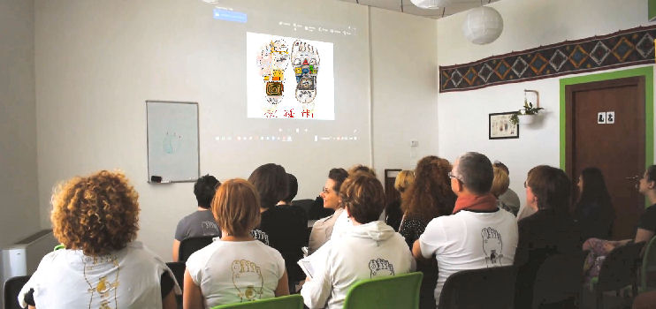 Momento coinvolgente dei corsi di riflessologia plantare della On Zon Su School: futuri riflessologi assistono ad una presentazione di slide