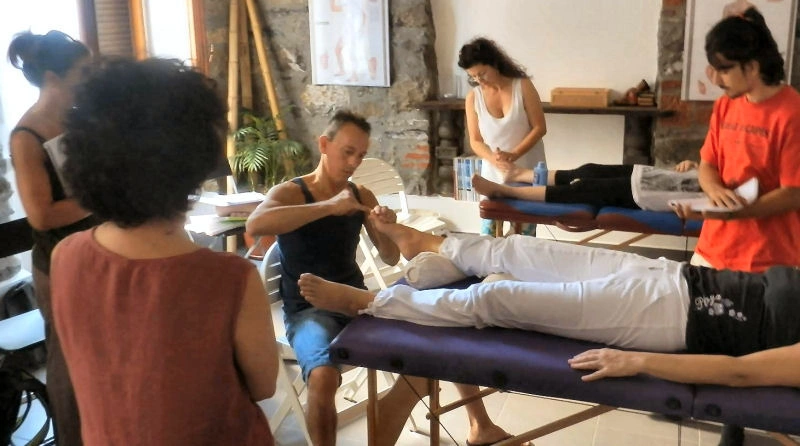 Studenti del corso professionale On Zon Su® durante una sessione pratica di riflessologia plantare su lettini, scambiandosi i ruoli di operatore e ricevente, nella sede di Lecco e Lario