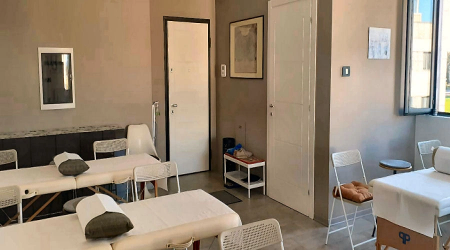 Interno della sede On Zon Su School a Parma con lettini e sedie predisposti per le lezioni di riflessologia plantare