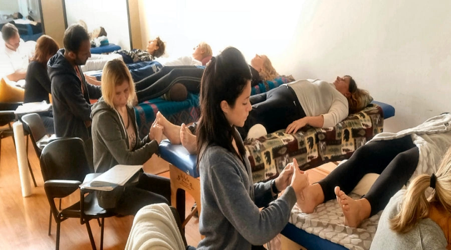 Allievi durante una lezione pratica di Riflessologia Plantare On Zon Su® a Verona, impegnati nelle tecniche manuali sui piedi