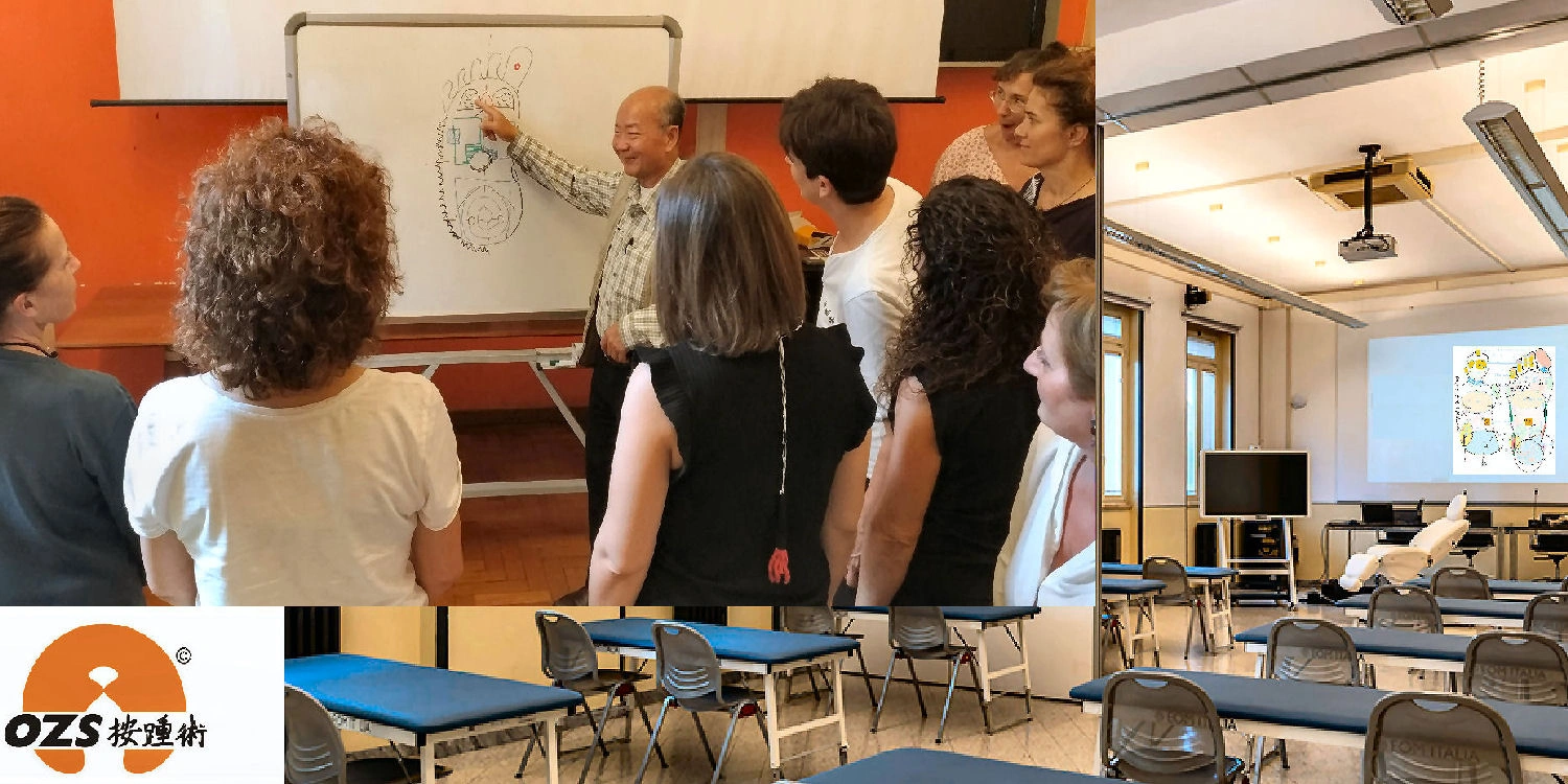 Maestro Ming che insegna tecniche di riflessologia plantare On Zon Su® a un gruppo di allievi in aula professionale con lettini da trattamento.